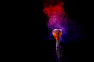 A brush with pink and blue make up powder impact to make a colorful cloud.