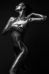 Fototapeta na wymiar fashion sexy girl gold-plated glittering posing (black and white photo)