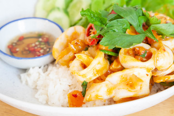 Closeup of stir fried squid with salted egg yolk served with steamed rice. Thai food.
