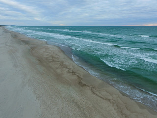 Top view of cold stormy and harsh Baltic sea. Empty off-season beach scene photographed with a drone.