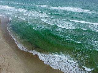Top view of cold stormy and harsh Baltic sea. Empty off-season beach scene photographed with a drone.