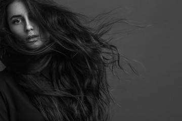 Portrait of a young beautiful girl with luxury hair flying (black and white photo)