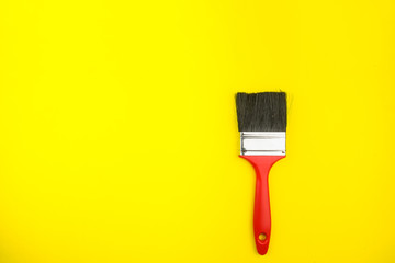 Top view of paint brushes on yellow background with copy space, minimalistic style