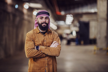 Young proud muslim investor with headscarf standing in building in construction process with arms crossed.