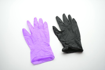 Two gloves of different colors on a white background. Medical gloves, latex, nitrile, multicolored, black, lilac, on a white background.