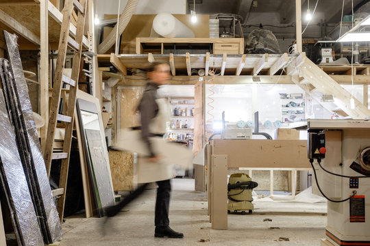Exposure photography two unidentified young employees of small woodworking and furniture industry working on new furniture collection. Concept of own small successful production