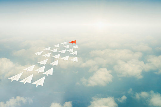 Successful business team work concept. Leadership concept with red paper airplane leading among group of white plane over sky, arrow shape. growth development progress success business