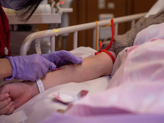 A nurse inserting a canula into a patient's arm