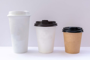 Paper cups with caps on grey background. Mock up.