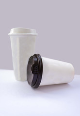 Paper cups with caps on grey background. Mock up.