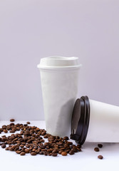 Paper cups with caps on grey background. Mock up.