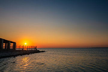 Dramatic sunrise with silky water view in Al uqair ruined fort sea side Saudi Arabia.