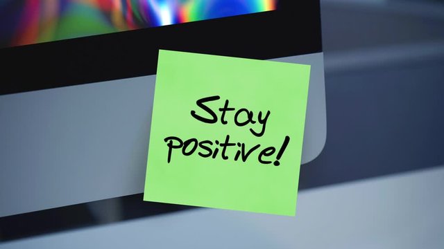Stay positive. Sticky notes. The inscription on the sticker on the monitor. Message. Motivation. Reminder. Life motto in the workplace. Handwritten text written with a marker. Color sticker.	