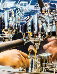 Espresso Machine pouring fresh coffee into cups at Local Coffee Shop..