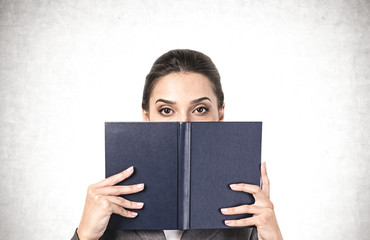 Woman covering her face with book