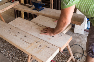 Male carpenter working on old wood in a retro vintage workshop.