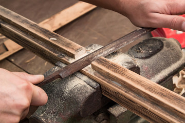 Male carpenter working on old wood in a retro vintage workshop.
