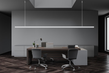 Modern gray CEO office with wooden table