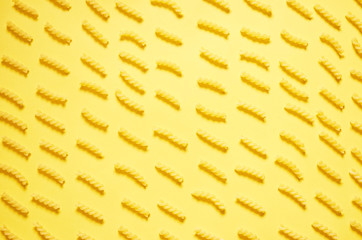 Pattern of pasta on a yellow background. The view from the top.