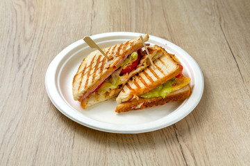 Meat sandwich on a plate with vegetables, fast food for breakfast