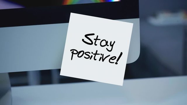 Stay positive. Sticky notes. The inscription on the sticker on the monitor. Message. Motivation. Reminder. Life motto in the workplace. Handwritten text written with a marker. Color sticker.	