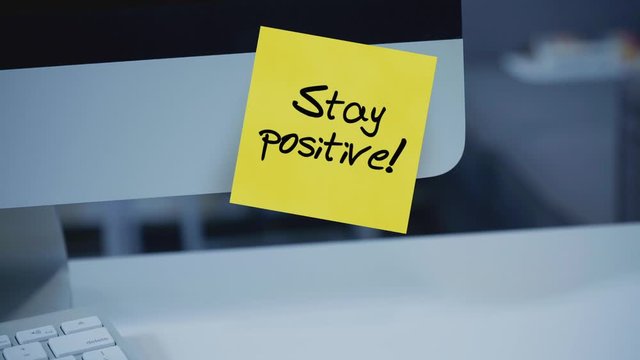 Stay positive. Sticky notes. The inscription on the sticker on the monitor. Message. Motivation. Reminder. Life motto in the workplace. Handwritten text written with a marker. Color sticker.	