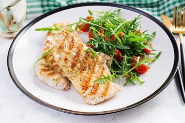 Grilled chicken fillet with fresh salad - arugula and tomato. Ketogenic food. Healthy lunch. Top view, flat lay, overhead