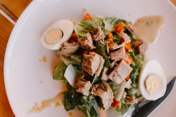 Salad on a white plate of green leaves with canned tuna, with an egg. Dietary food. Proper nutrition.