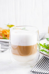 Coffee cafe latte macchiato in a glass on  light background. Italian cuisine