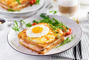 Breakfast.  Hot sandwich. Croque madame sandwich and a cup of latte macchiato coffee on the table. French cuisine. Copy space