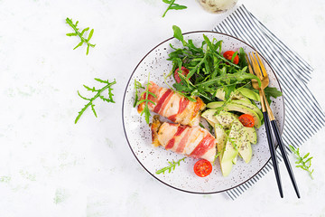 Ketogenic diet. Dinner dish with chicken meat roll wish  bacon, avocado, tomatoes and arugula. Detox and healthy concept. Keto food. Overhead, top view, flat lay