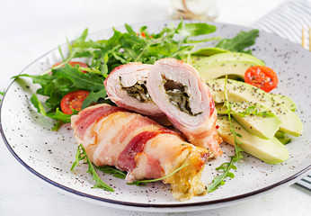 Ketogenic diet. Dinner dish with chicken meat roll wish  bacon, avocado, tomatoes and arugula. Detox and healthy concept. Keto food.