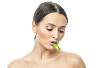 portrait of a girl with clean skin without makeup with a leaf of green salad