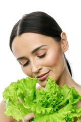 portrait of a girl with clean skin without makeup with a leaf of green salad