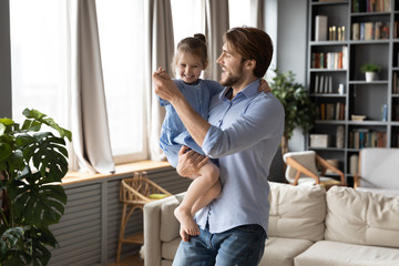 Happy loving young father have fun dancing swaying swirling with cute little preschooler daughter,...