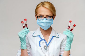 medical doctor nurse woman wearing protective mask and gloves - holding virus blood test tube