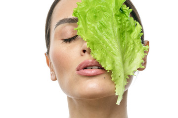 portrait of a girl with clean skin without makeup with a leaf of green salad