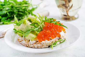 Crispbread sandwiches with red caviar, avocado and cream cheese  in plate.