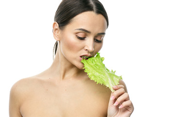 portrait of a girl with clean skin without makeup with a leaf of green salad