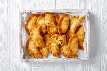 deep fried empanadas in a wooden box