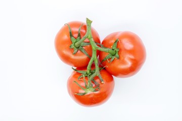 Beautiful ripe red tomatoes are located on a white background