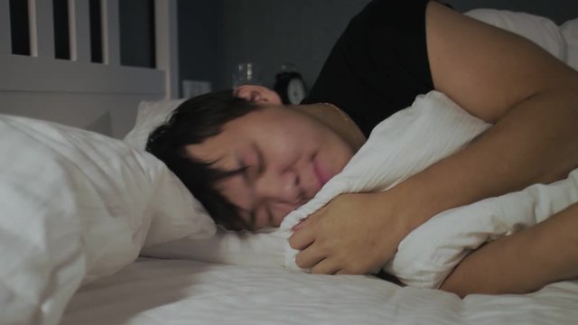 Close up of young asian man lying and sleeping in the bed at home.