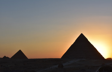 Obraz na płótnie Canvas beauty sunset background of pyramids giza CAIRO EGYPT.Silhouette pyramids when sunset and orange sky