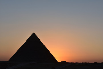 Obraz na płótnie Canvas beauty sunset background of pyramids giza CAIRO EGYPT.Silhouette pyramids when sunset and orange sky