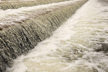 Running water. Waterfall. The flow of water. Foam in the water. Bubble on the water.