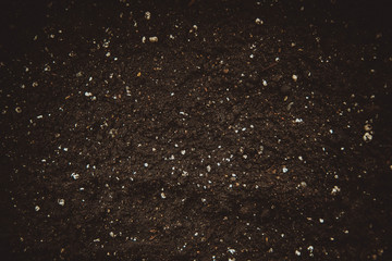 Fertile soil suitable for planting with mineral fertilizers, soil texture background.