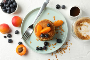 Composition with pancakes and fruits on white background, top view