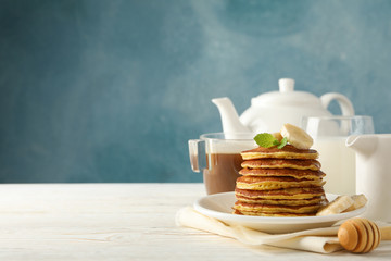 Composition with pancakes, milk and cocoa drink on wooden table. Sweet breakfast