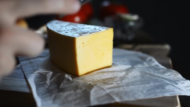 Chef Cheese sliced ​​with a knife for salad and pizza in a restaurant and at home