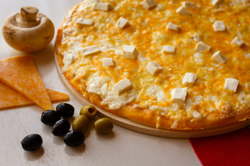 Hot italian pizza on a table with vegetables